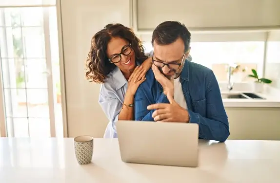Couple smiling at laptop