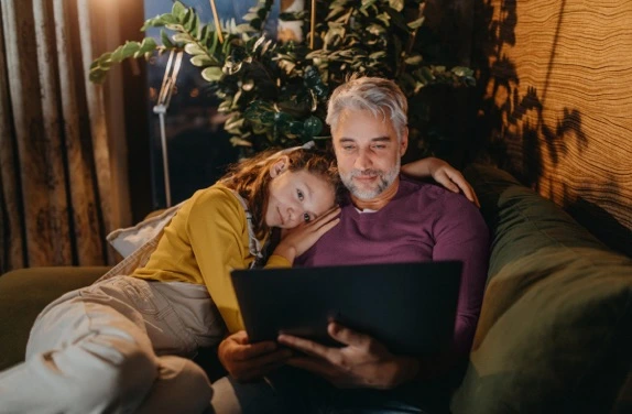 father and daughter sitting on a couch
