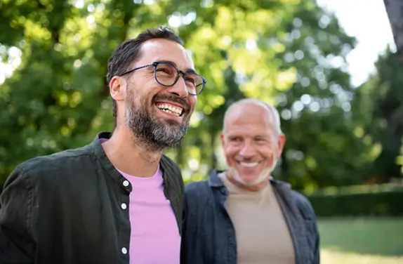 Young and older male outside smiling