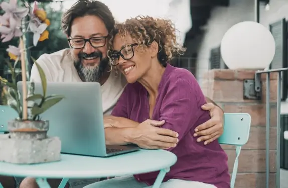 Man and woman looking smiling at laptop