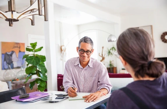 man in glasses writing on a notepad