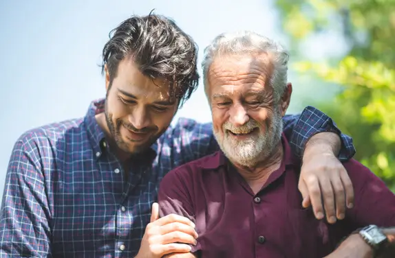 Two men smiling looking down